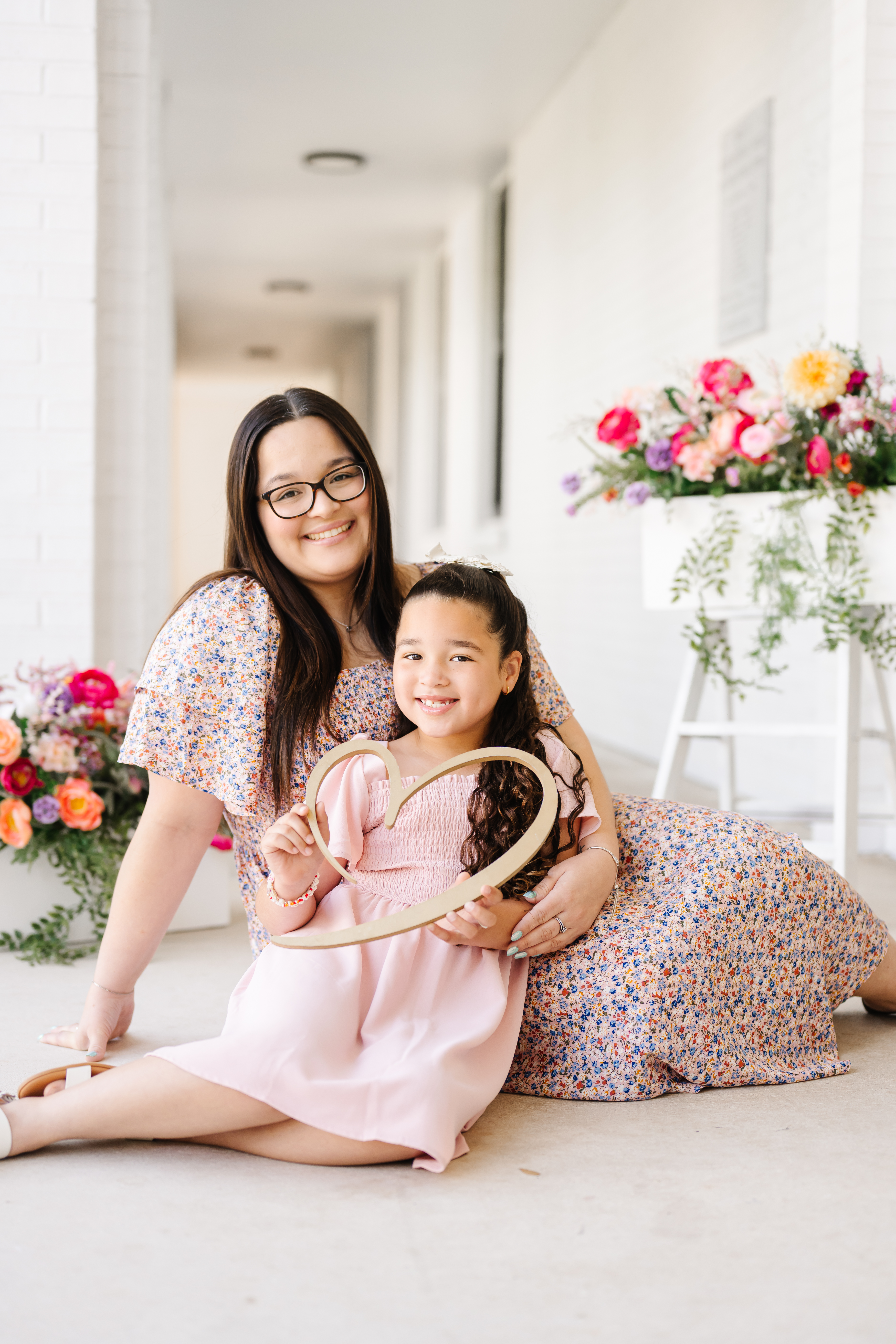 Mother and young daughter holding heart