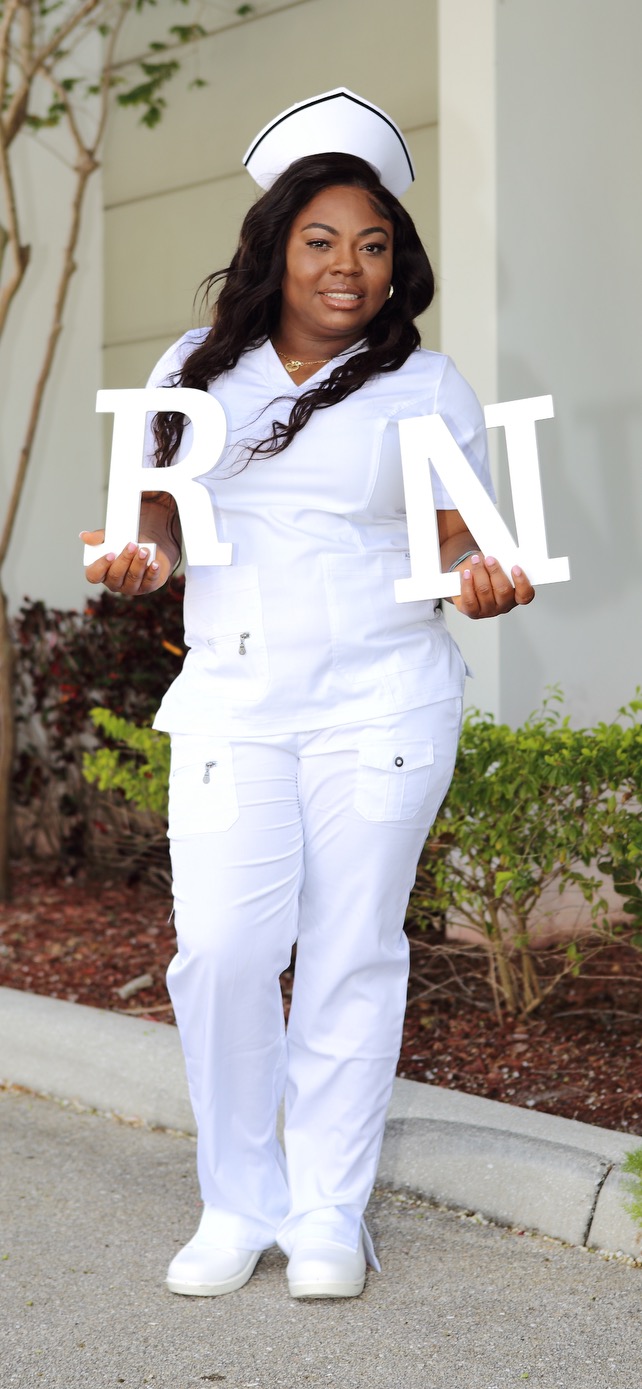 Graduating nurse holding R N letter sign